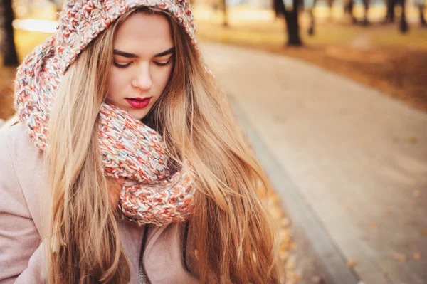 Retrato da jovem mulher bonita andando em roupa quente elegante no dia ensolarado de outono no parque, vestindo casaco rosa e snood de malha. Estilo de vida casual na cidade — Fotografia de Stock