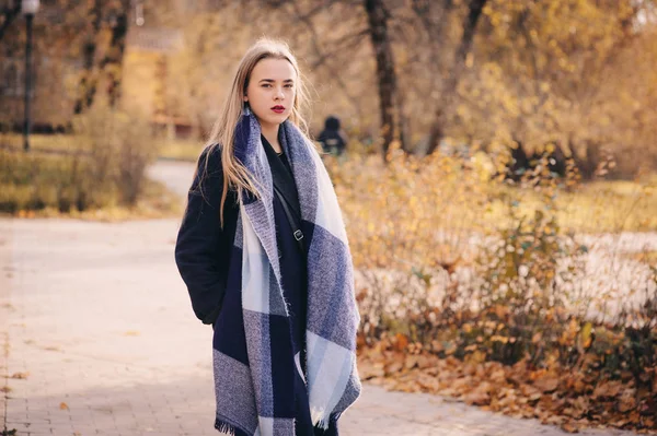 Autumn outdoor casual portrait of young beautiful woman walking in park in warm fashion outfit, weraing coat and scarf — Stock Photo, Image