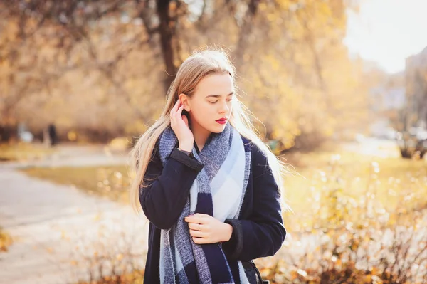 Осенний открытый случайный портрет молодой красивой женщины, гуляющей в парке в теплой одежде моды, пальто и шарф — стоковое фото