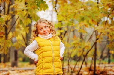 Şirin Bebek kız ile oynamaktan sonbahar parkta yürüyüş üzerinde moda sarı kıyafeti giymiş bırakır 