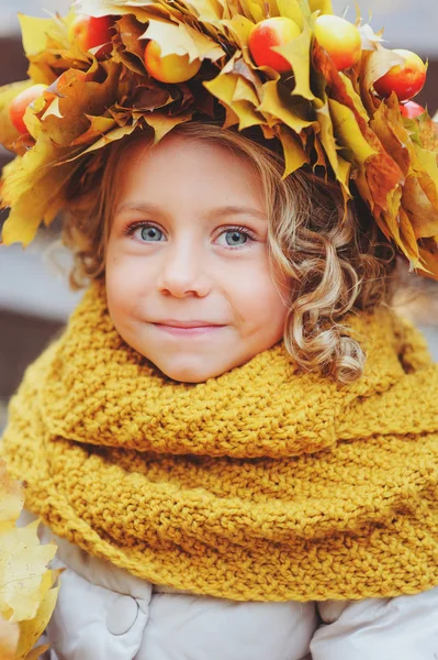 Roztomilý rozkošný batole dívka vertikální portrét s kytice podzimní listí a věnec chůzi venkovní v parku nebo v lese, na sobě teplé pletené žluté snood — Stock fotografie