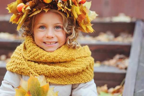 Roztomilý rozkošný batole dívka vertikální portrét s kytice podzimní listí a věnec chůzi venkovní v parku nebo v lese, na sobě teplé pletené žluté snood — Stock fotografie