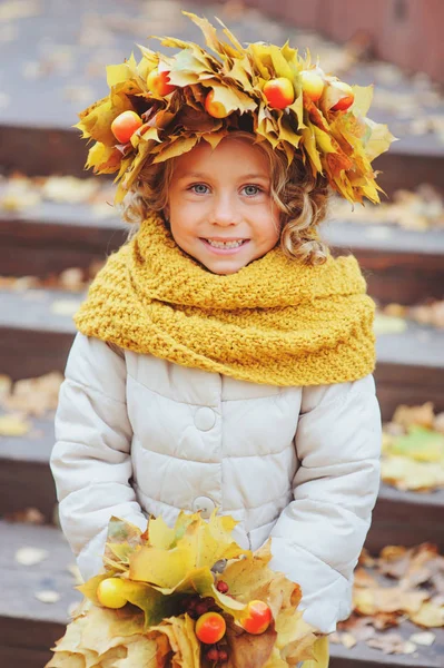 Bonito adorável criança menina vertical retrato com buquê de folhas de outono e grinalda andando ao ar livre no parque ou na floresta, vestindo quente malha amarelo snood — Fotografia de Stock