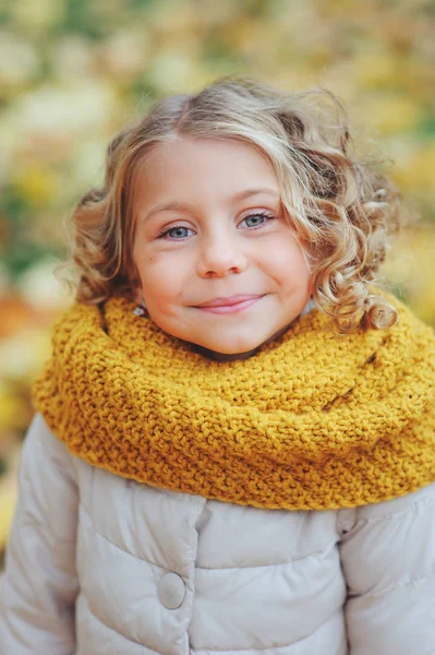 Kisgyermek boldog lány séta kültéri elegáns kötött narancssárga fonalat vicces őszi portréja — Stock Fotó