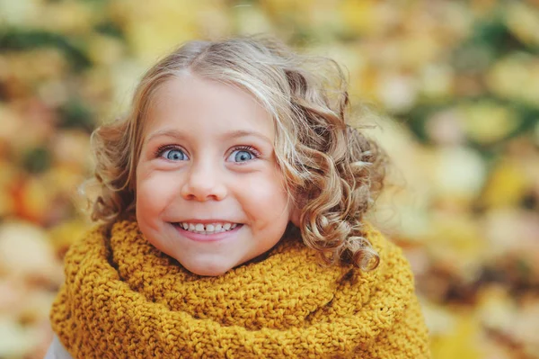 Rolig höst porträtt av glada barn girl promenader utomhus i snygg stickad orange snood — Stockfoto