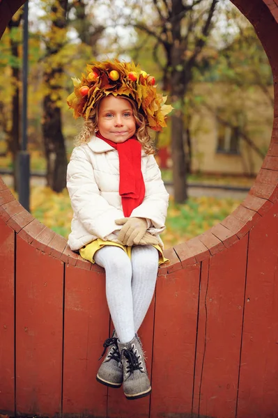 Bonito adorável criança menina vertical retrato com buquê de folhas de outono e grinalda andando ao ar livre no parque ou na floresta, vestindo quente malha amarelo snood — Fotografia de Stock