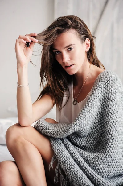 Young sexy woman relaxing at home in bed in weekend morning, wrapped in knitted blanket. Casual lifestyle — Stock Photo, Image