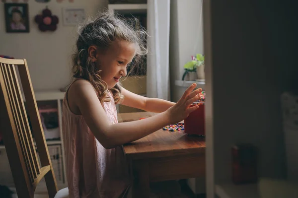 Niña feliz jugando con mosaico en casa en su habitación — Foto de Stock