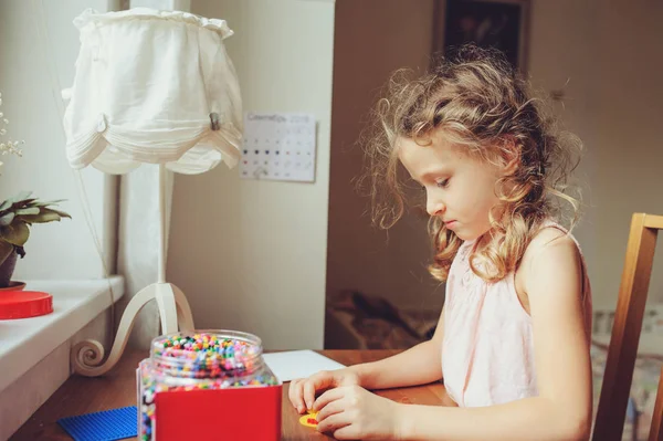 Happy child girl playing with mosaic at home in her room — Stock Photo, Image