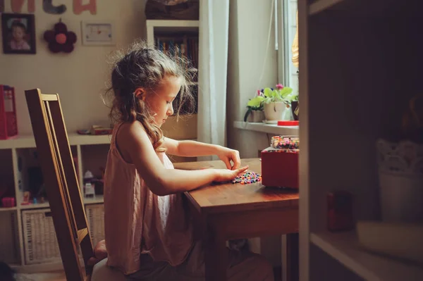 Bambino felice ragazza che gioca con mosaico a casa nella sua stanza — Foto Stock