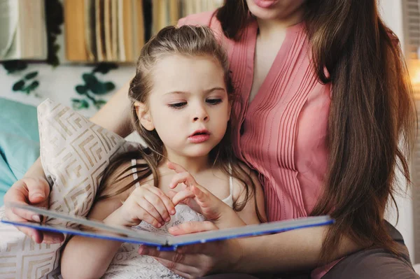 Anne için yürümeye başlayan çocuk kızı yatak odasında iyi geceler için kitap okumak. Mutlu aile evde rahat yaşam tarzı yakalanması — Stok fotoğraf