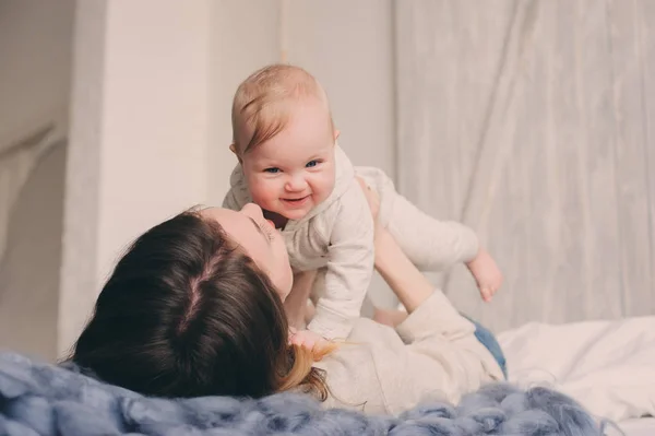 Mutlu anne ve bebek yatak odalı evde oynarken. Rahat aile yaşam tarzı modern İskandinav iç. — Stok fotoğraf