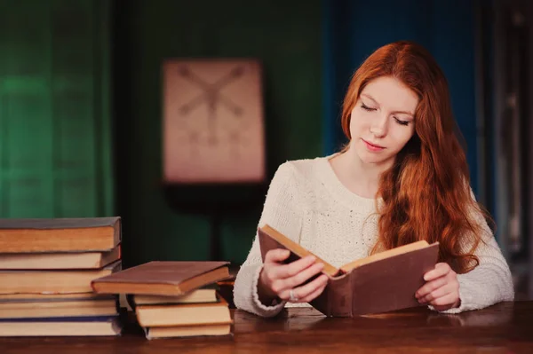 Joven hermosa pelirroja aprendizaje en la biblioteca y lectura de libros — Foto de Stock