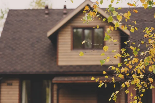 Коричневый деревянный домик осенью вечером — стоковое фото