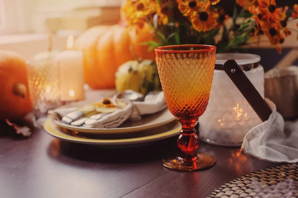 Autumn traditional seasonal table setting at home with pumpkins, candles and flowers. Family celebrating Thanksgiving day. — Stock Photo, Image