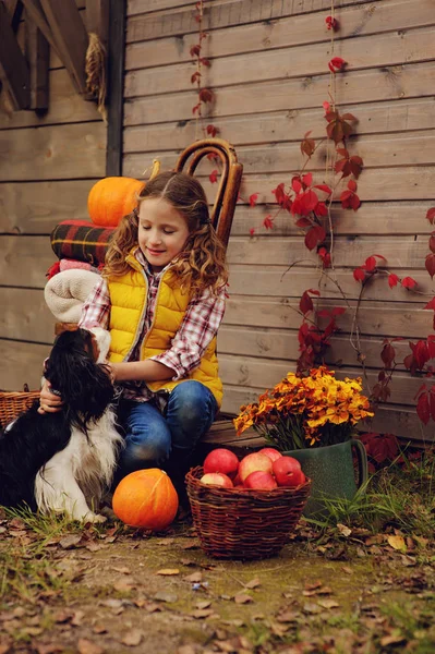 Šťastné dítě dívka výdeje čerstvá jablka na farmě. Země koncept bydlení, útulné sezónní dekorace na pozadí — Stock fotografie