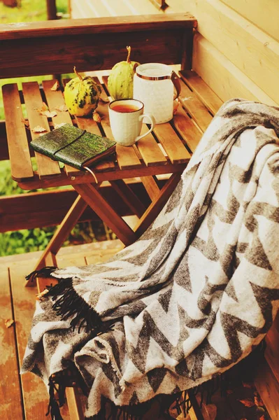 sonbahar sabahı rahat kır evi, fincan çay ve sıcak bir battaniye ahşap masa var. Natürmort ayrıntıları