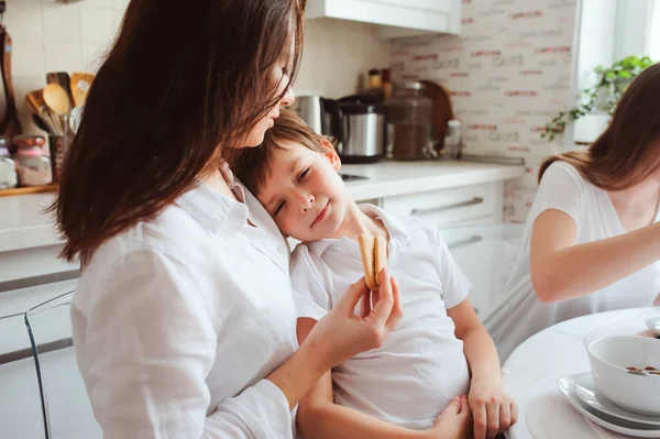 Mutlu bir aile evde kahvaltı. Modern beyaz mutfakta yemek iki çocuklu anne — Stok fotoğraf