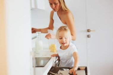 modern beyaz mutfak, sabahları rahat yaşam tarzı çocuk kızı evde kahvaltı yapıyor anne