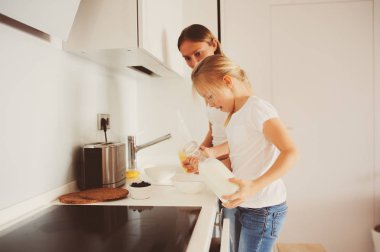 modern beyaz mutfak, sabahları rahat yaşam tarzı çocuk kızı evde kahvaltı yapıyor anne