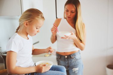 modern beyaz mutfak, sabahları rahat yaşam tarzı çocuk kızı evde kahvaltı yapıyor anne