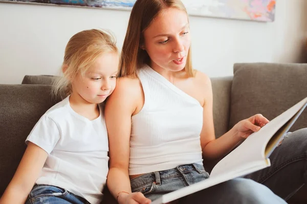 Anya olvasó könyv kisgyermek lánya, a hálószobában, jó éjszakát. Alkalmi életmód elfog boldog család otthon — Stock Fotó