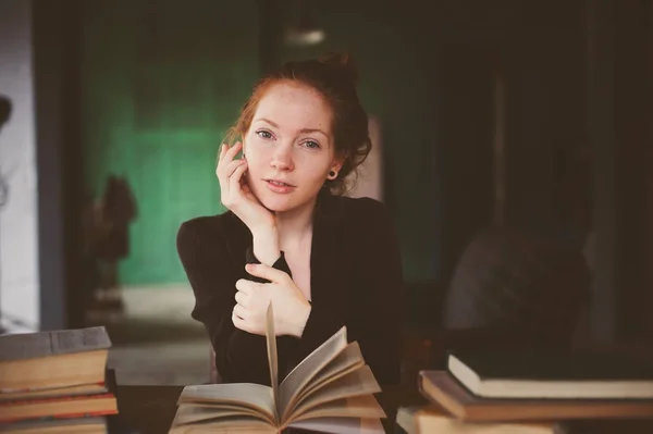 Portrait intérieur de rousse heureuse femme apprenant ou lisant des livres à l'université ou à la bibliothèque — Photo