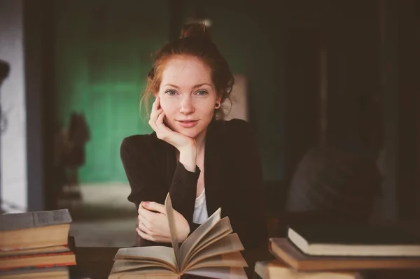 Portrait intérieur de rousse heureuse femme apprenant ou lisant des livres à l'université ou à la bibliothèque — Photo