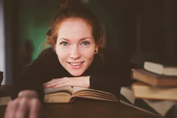 Portrait intérieur de rousse heureuse femme apprenant ou lisant des livres à l'université ou à la bibliothèque — Photo