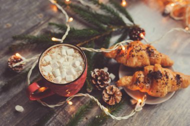 sıcak kakao marshmallows ve kruvasan Noel ışıkları rustik ahşap tablo. Sıcacık kış ev concept