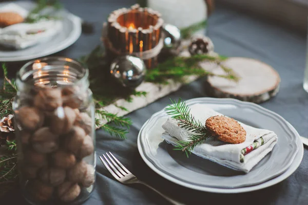 Festlig jul och nyårsdukning i skandinavisk stil med rustika handgjorda detaljer i naturliga och vita toner. Matplats dekorerad med kottar, grenar och ljus — Stockfoto