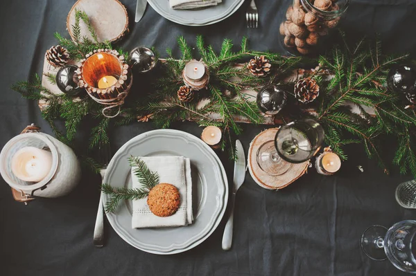 Festive Christmas and New Year table setting in scandinavian style with rustic handmade details in natural and white tones. Dining place decorated with pine cones, branches and candles — Stock Photo, Image