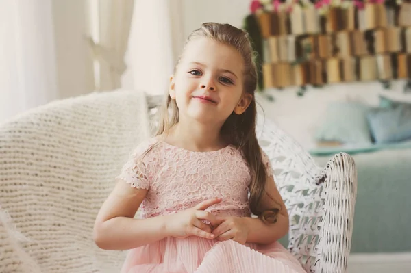 Retrato de linda sonrisa niña de 5 años sentada en la silla en casa — Foto de Stock