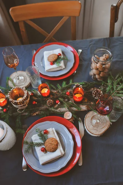 Natale festivo e Capodanno tavola impostazione in toni rossi e grigi. Sala da pranzo per la celebrazione con dettagli rustici fatti a mano e candele — Foto Stock
