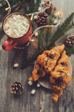 sıcak kakao marshmallows ve kruvasan Noel ışıkları rustik ahşap tablo. Sıcacık kış ev concept