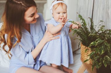 mutlu anne ve pijama yatak odasında sabah oynamaya uygun 9 aylık bebek. Rahat aile hafta sonu.