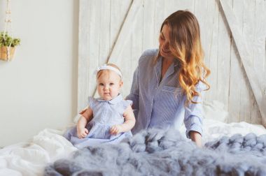 mutlu anne ve pijama yatak odasında sabah oynamaya uygun 9 aylık bebek. Rahat aile hafta sonu.