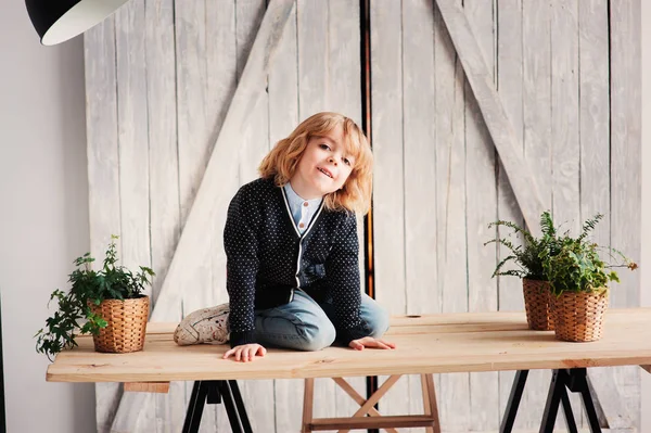 Fotografování portrétů chlapce 5 let s dlouhými vlasy sedí na stole doma — Stock fotografie