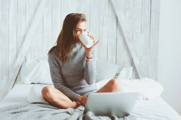 Young blogger or business woman working at home with social media, drinking coffee in early morning in bed. Modern living in scandinavian interior, casual lifestyle — Stock Photo, Image