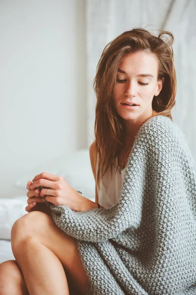 Jovem mulher sexy relaxante em casa na cama no aconchegante fim de semana de inverno manhã, envolto em manta de malha quente — Fotografia de Stock