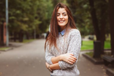 de klimalı uzun siyah saçlı genç güzel mutlu kız sıcak örme kazak sonbahar şehirde yürüyüş portresi kapatın