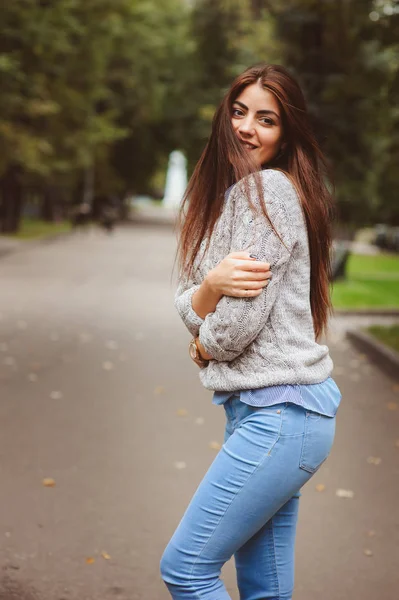 Primer plano retrato de joven hermosa chica feliz con el pelo largo oscuro bien acondicionado, caminando en la ciudad de otoño en suéter de punto cálido —  Fotos de Stock