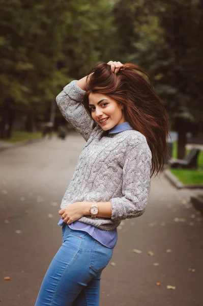 Close up retrato de jovem bela menina feliz com cabelo escuro longo bem condicionado, andando na cidade de outono em suéter de malha quente — Fotografia de Stock