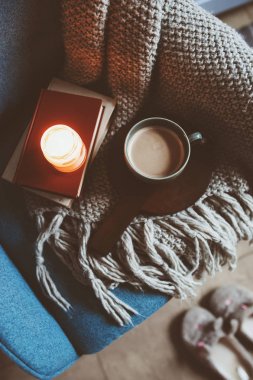 Evde rahat kış hafta sonu. Sabah kahve veya kakao, kitaplar, sıcak battaniye ve İskandinav tarzı sandalye ördü. Hygge kavramı.
