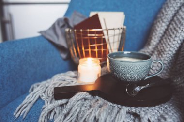 Evde rahat kış hafta sonu. Sabah kahve veya kakao, kitaplar, sıcak battaniye ve İskandinav tarzı sandalye ördü. Hygge kavramı.