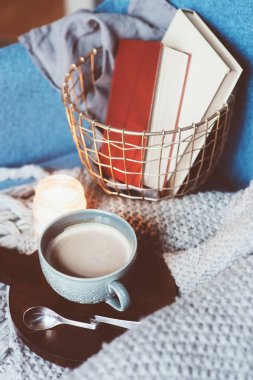 Evde rahat kış hafta sonu. Sabah kahve veya kakao, kitaplar, sıcak battaniye ve İskandinav tarzı sandalye ördü. Hygge kavramı.