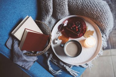 Evde rahat kış hafta sonu. Sabah kahve veya kakao, kitaplar, sıcak battaniye ve İskandinav tarzı sandalye ördü. Hygge kavramı.