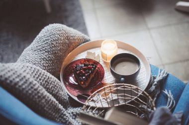 Evde rahat kış hafta sonu. Sabah kahve veya kakao, kitaplar, sıcak battaniye ve İskandinav tarzı sandalye ördü. Hygge kavramı.