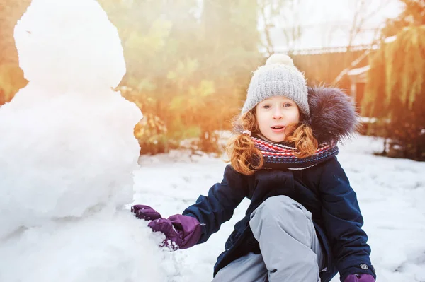 Glückliches Kind Mädchen Macht Schneemensch Auf Weihnachtsurlaub Auf Hinterhof Outdoor — Stockfoto