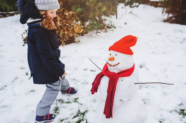 Szczęśliwy Dziewczyna Człowiek Śniegu Boże Narodzenie Wakacje Podwórku Zimowe Atrakcje — Zdjęcie stockowe